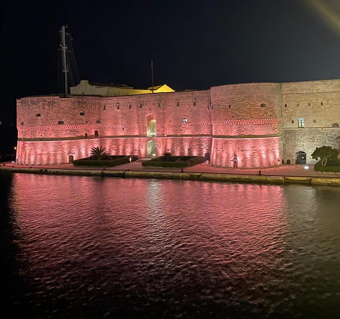 Il Castello Aragonese illuminato di magenta