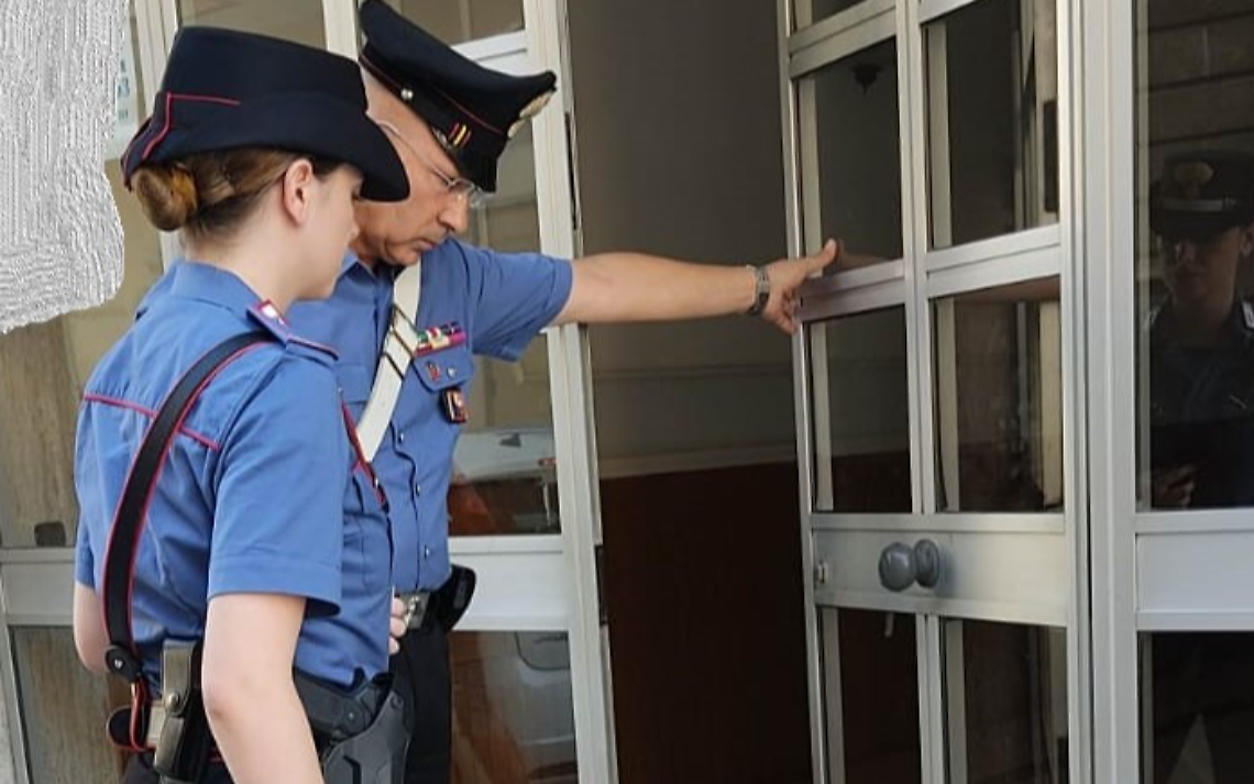 Il portone danneggiato. L'intervento dei Carabinieri