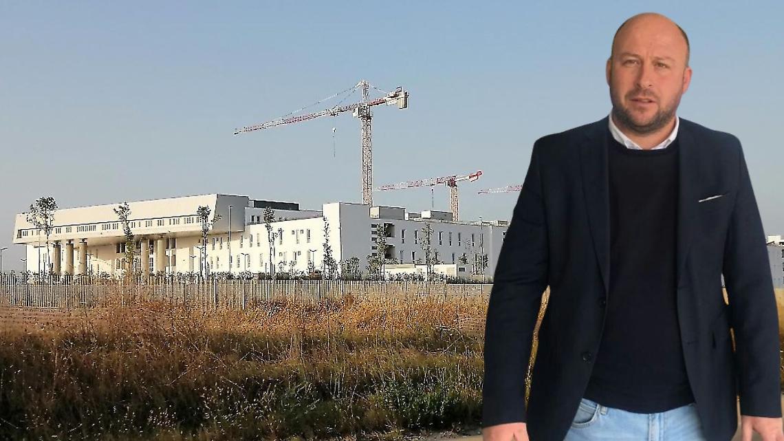 Il consigliere regionale Renato Perrini. Sullo sfondo, il nascente ospedale San Cataldo