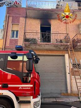 La casa in fiamme, attende i soccorsi sul balcone